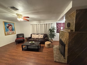 Relax in this inviting living room with a leather sofa, coffee table, and stone fireplace.