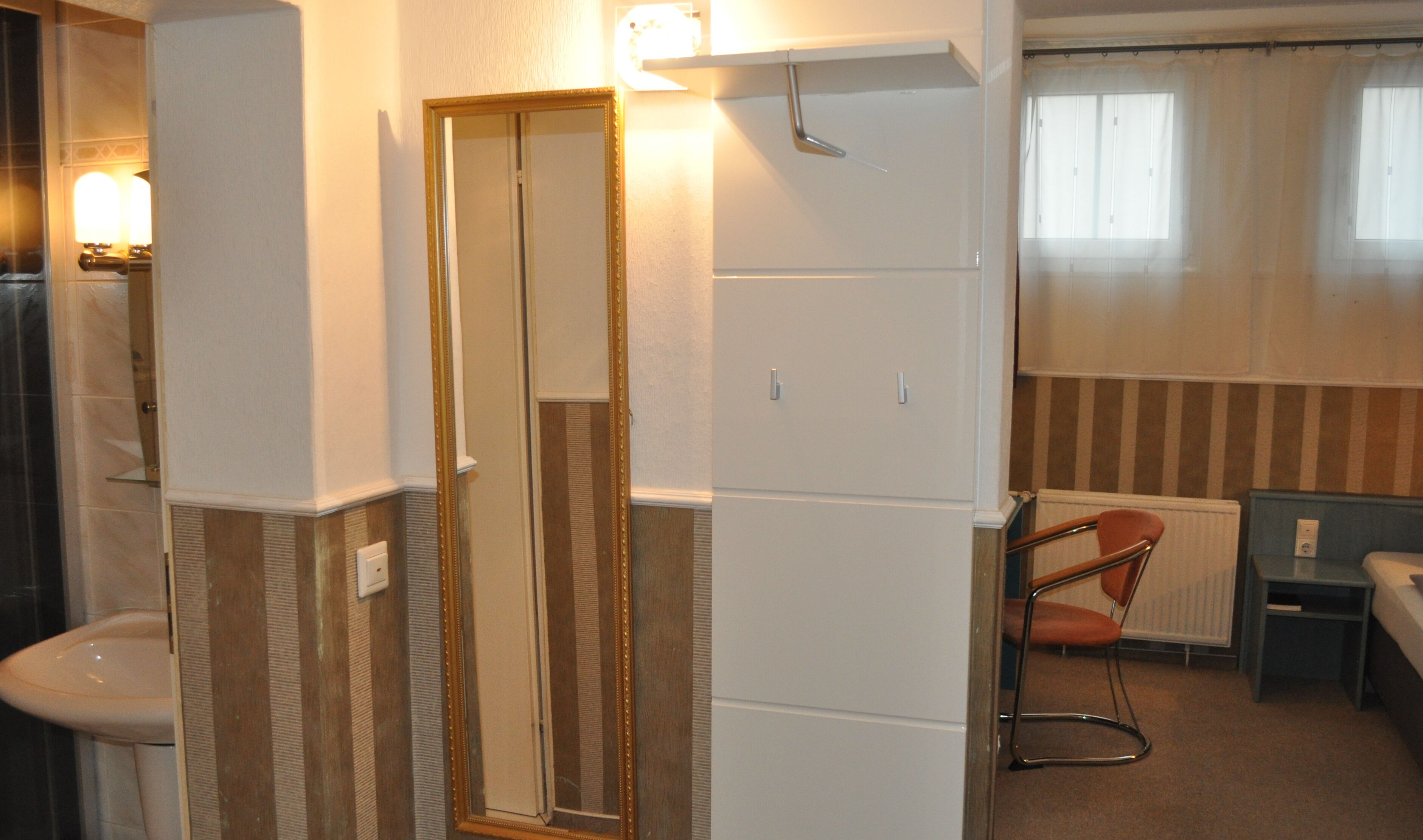 Une salle de bain comprenant un miroir, des toilettes, un lavabo et un espace douche.