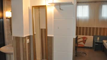 Une salle de bain comprenant un miroir, des toilettes, un lavabo et un espace douche.
