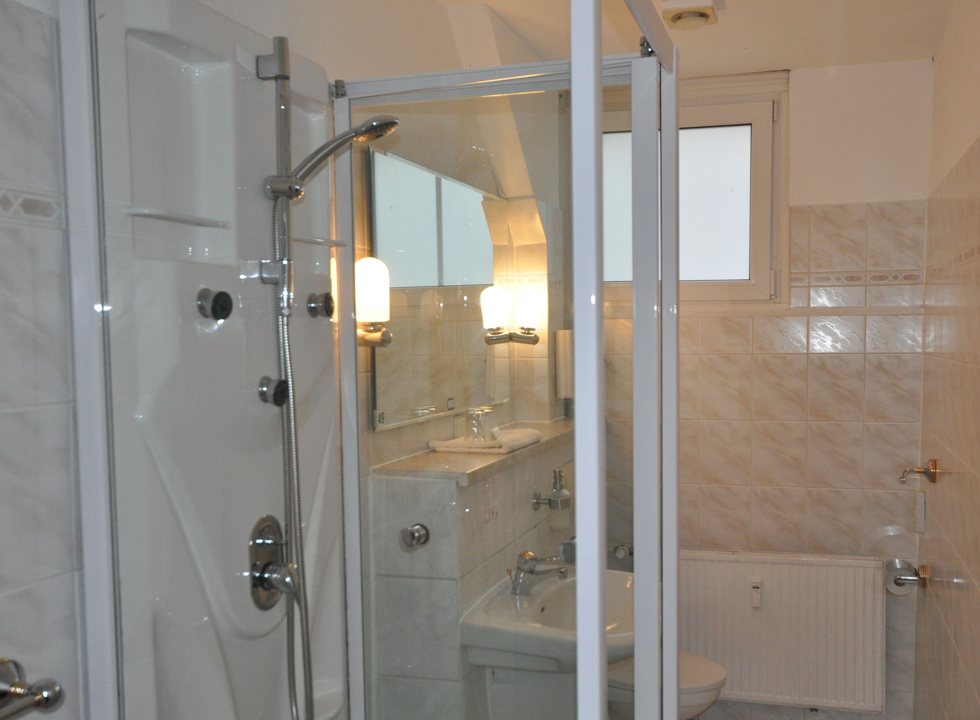 Une salle de bain moderne avec une douche à parois de verre, un lavabo et des toilettes.