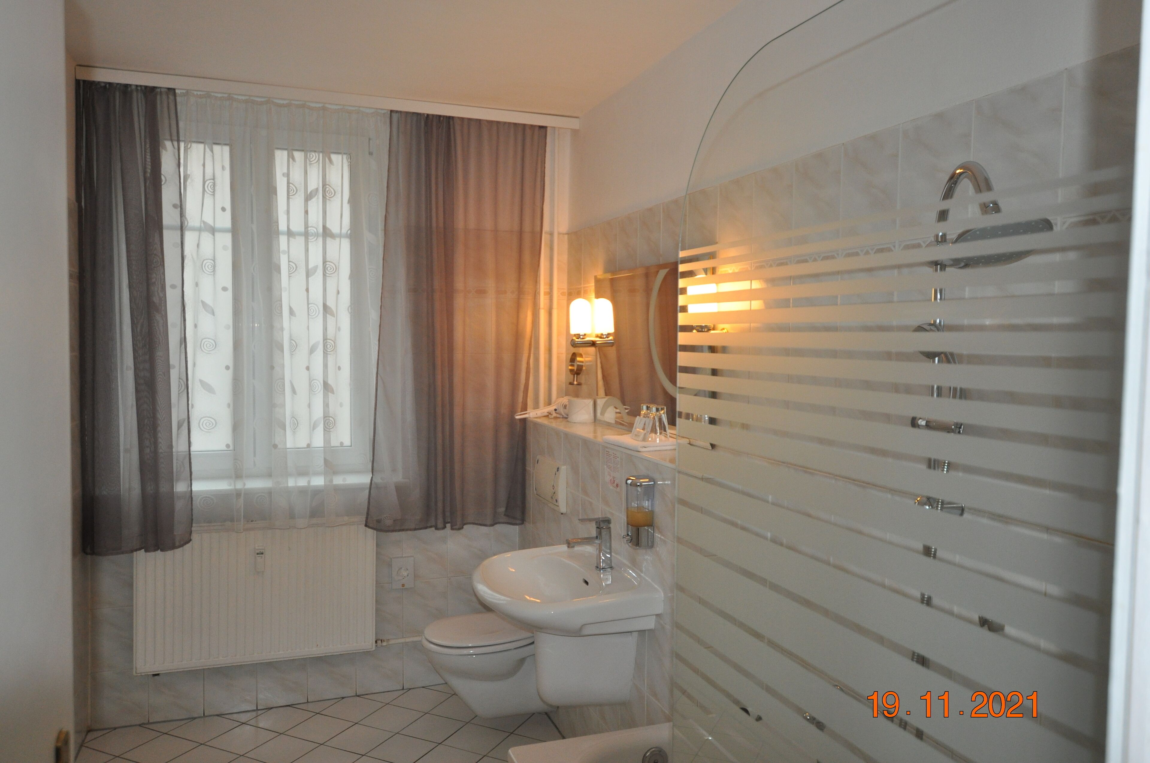 A modern bathroom with a toilet, sink, and a glass shower enclosure.