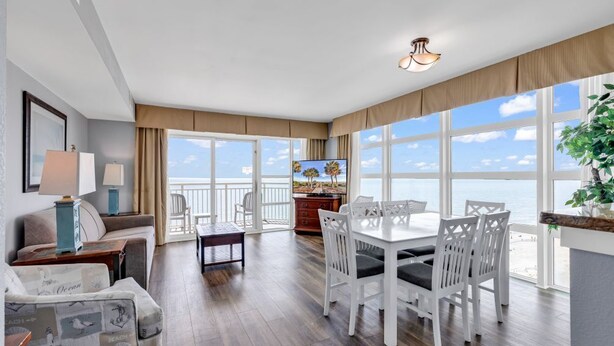 Ein geräumiges Zimmer mit Balkon, Essbereich und großem Fenster mit Meerblick.