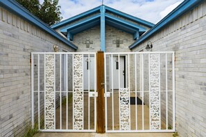 Stunning entrance with a beautifully designed gate and brick facade.