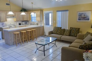 Cozy living space with a central kitchen island, sofa, and coffee table.