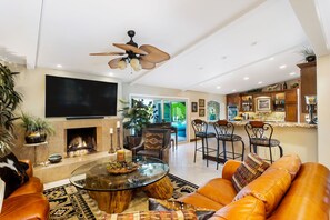 Relax in this stylish living room with a large flat-screen TV, comfortable seating area, and fireplace.