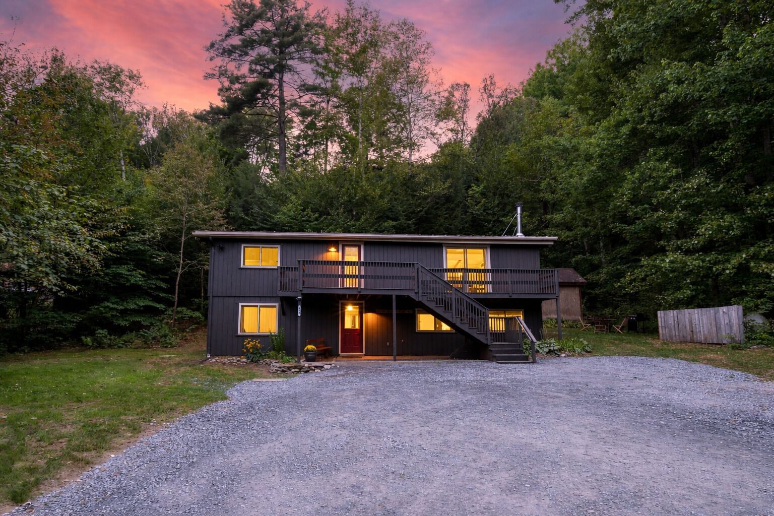 The front of the cabin with a walk out porch at dusk. 