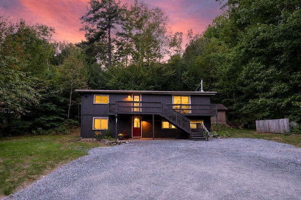 The front of the cabin with a walk out porch at dusk.