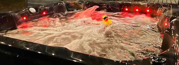 Une grande installation aquatique intérieure, avec une fontaine centrale et des jeux de lumière tout autour.