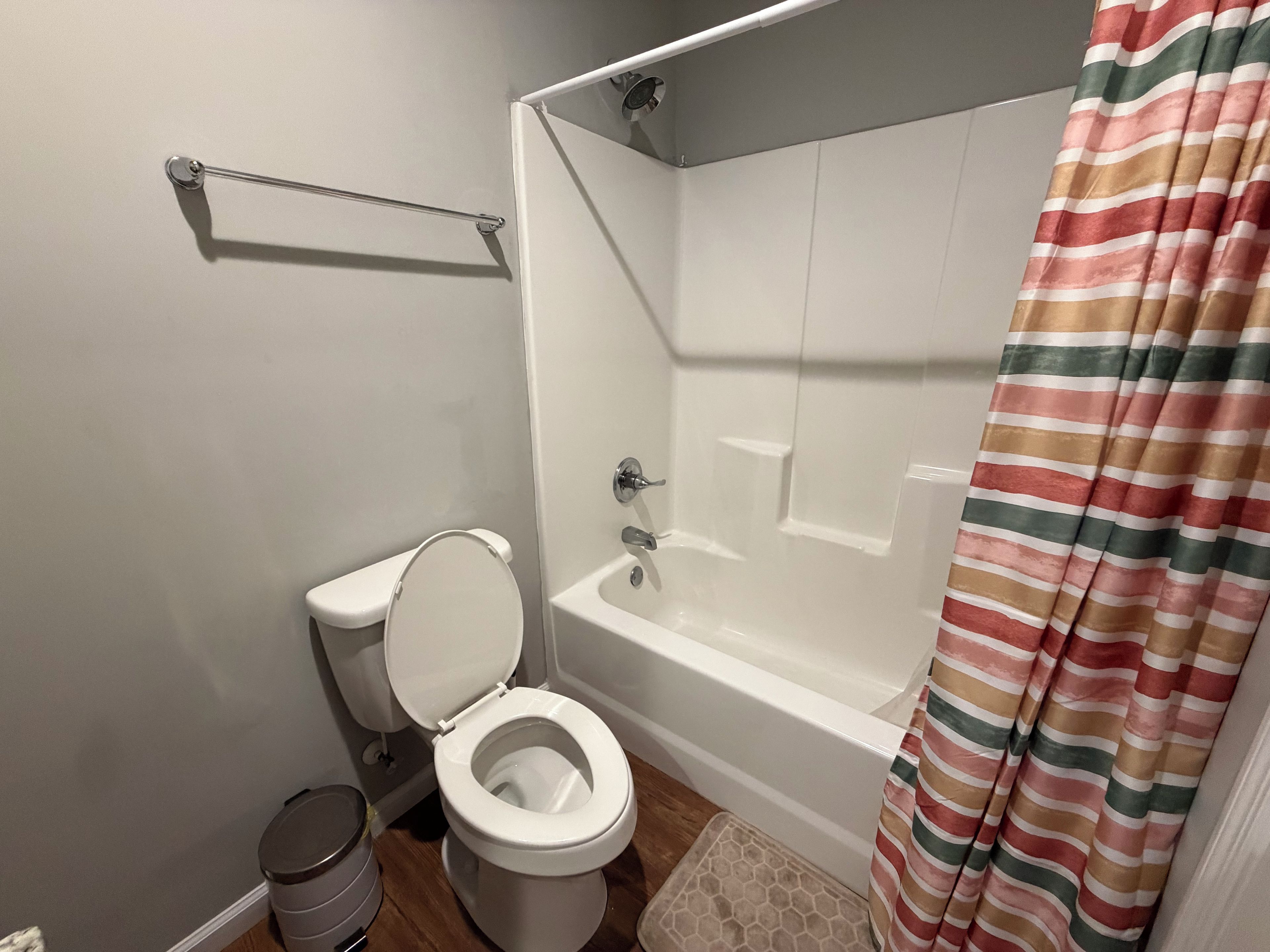 Un baño con inodoro, bañera y cortina de ducha.