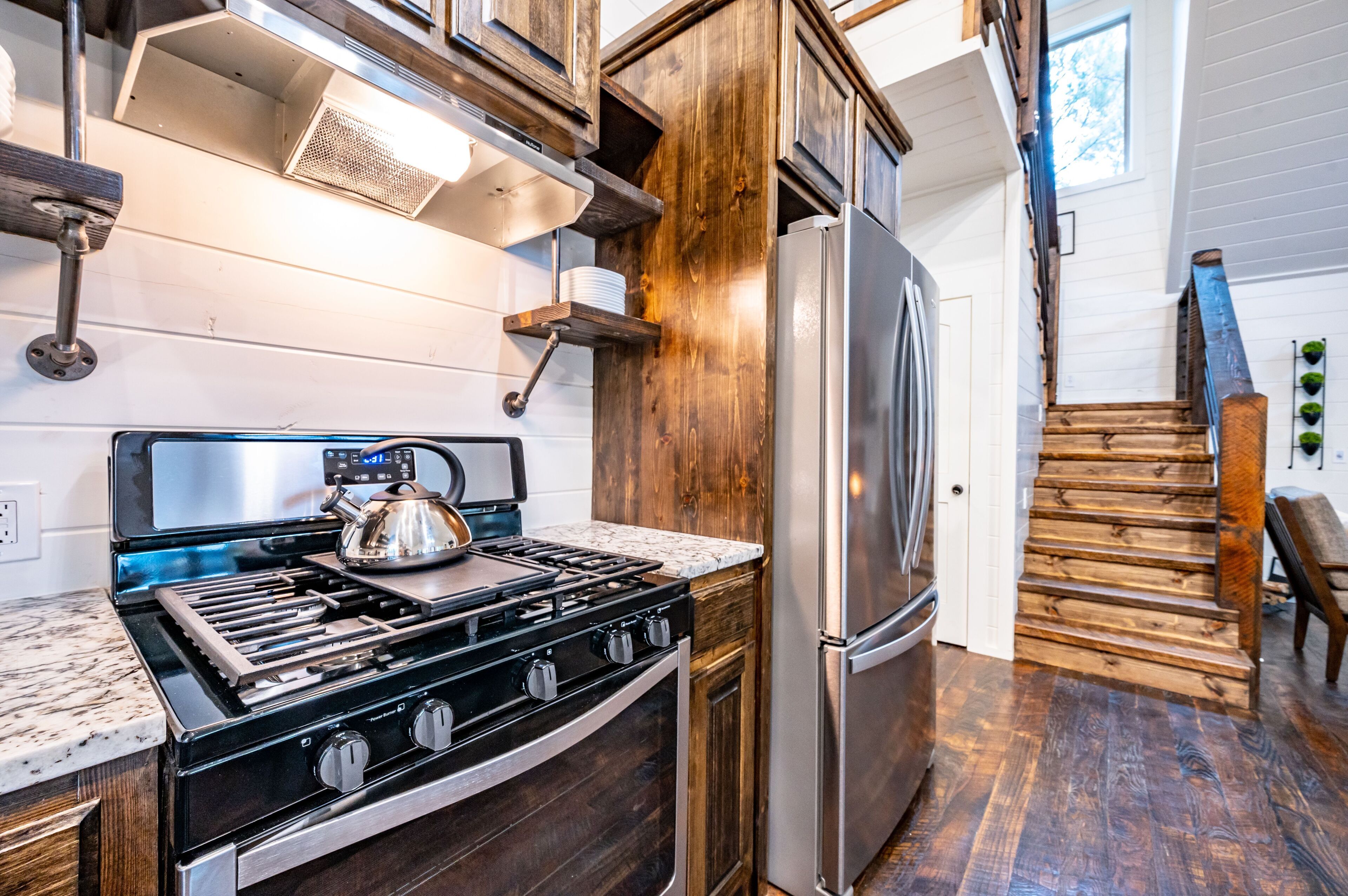 A kitchen with a stainless steel stove, wooden cabinets, and a built-in oven.