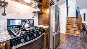 A kitchen with a stainless steel stove, wooden cabinets, and a built-in oven.
