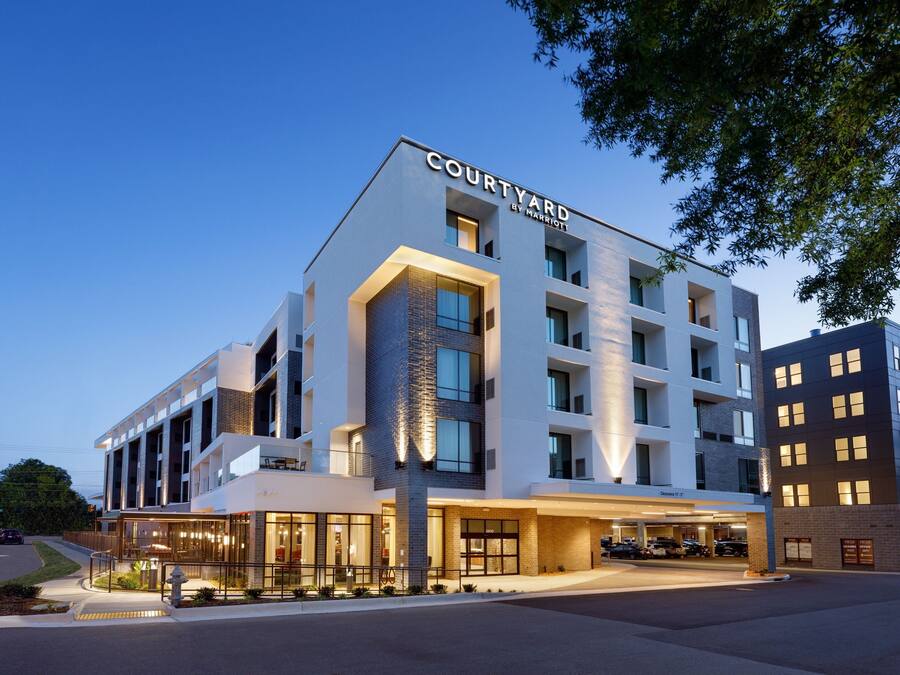 Ett Courtyard by Marriott-hotell med modern design, stora fönster och en väl upplyst entré.