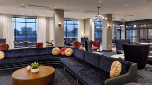 A modern hotel lobby with a large sectional sofa, round coffee table, and various seating options. - Courtyard by Marriott Richmond Scott’s Addition (Richmond)