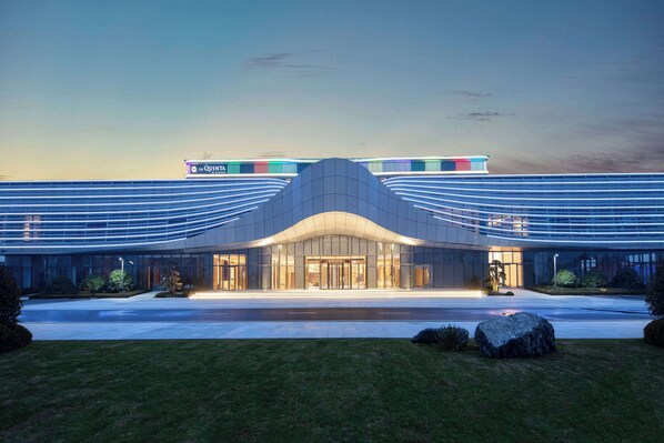 Un bâtiment moderne avec une entrée incurvée et une enseigne indiquant « La Quinta ».