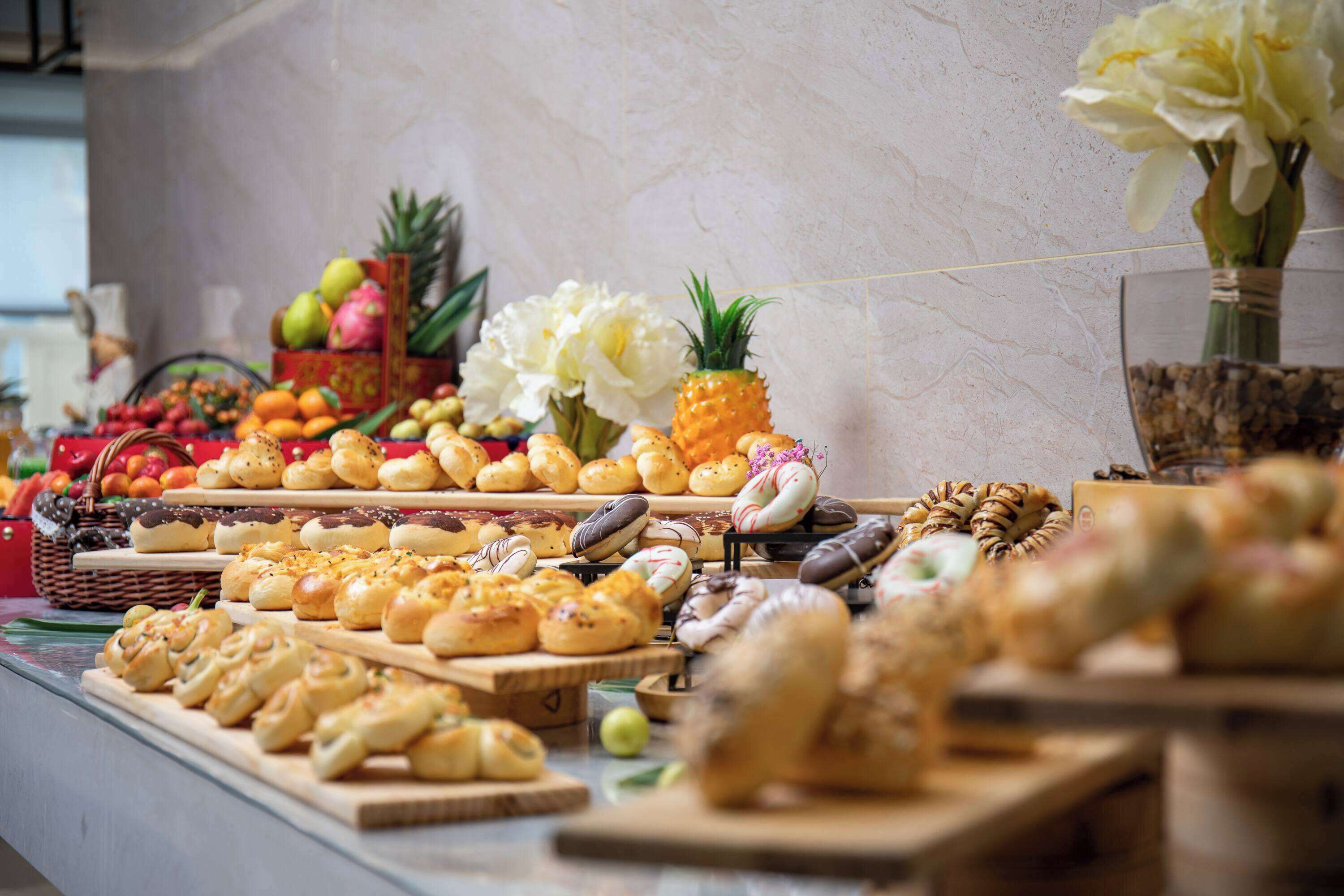 Un bufé con diversos productos horneados y frutas.