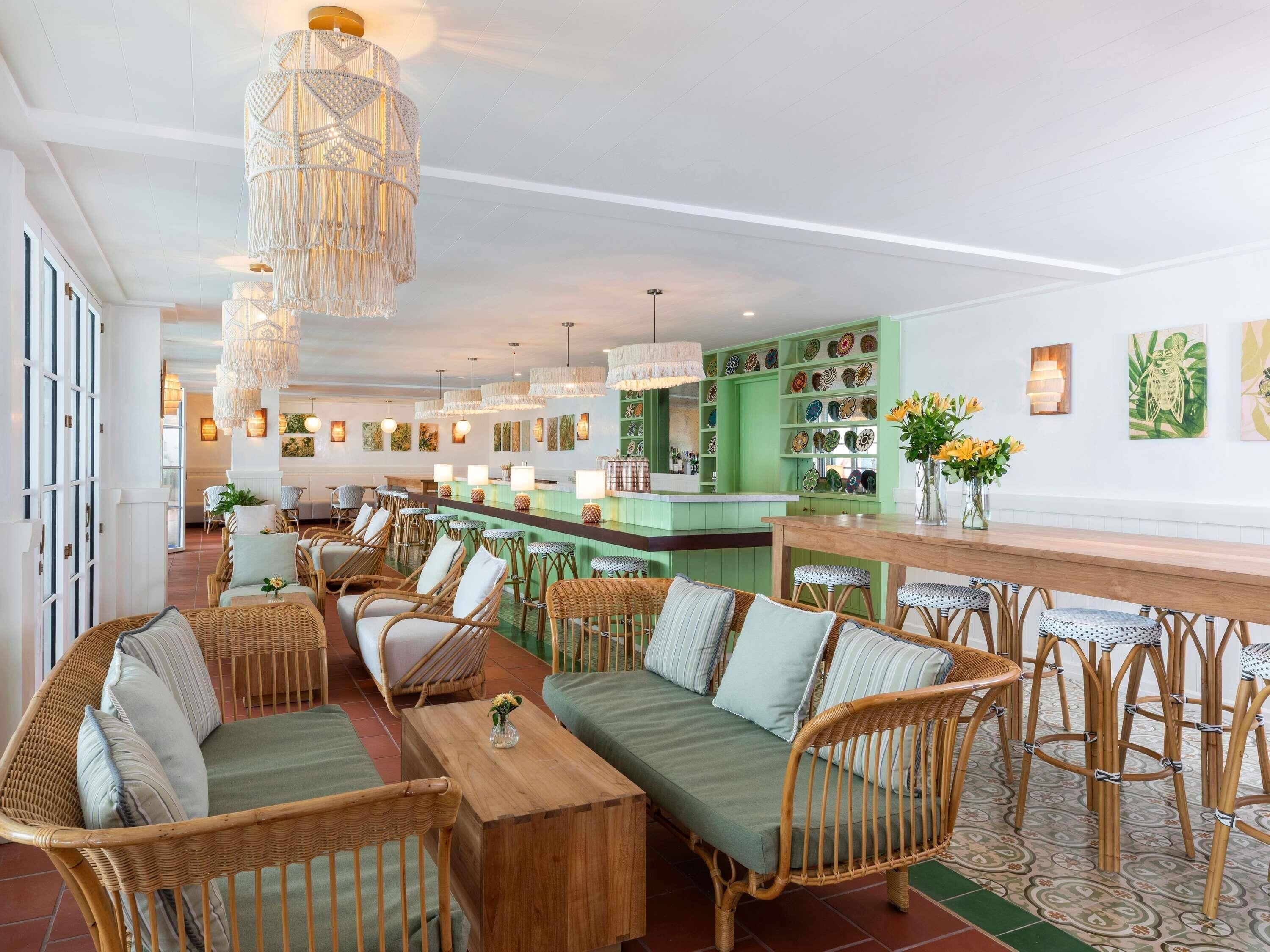 A spacious bar area with wicker furniture and a green bar counter.