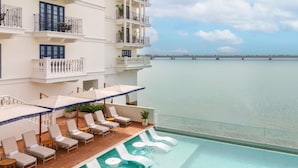 A hotel with a rooftop pool, lounge chairs, and a view of the sea. - Sofitel Legend Casco Viejo, Panama City  (Panama City)
