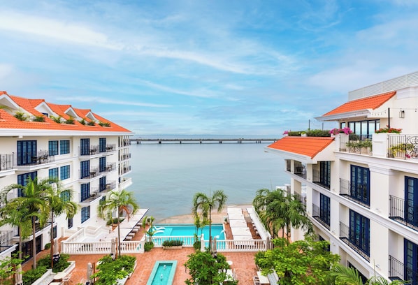 Un hotel con varios balcones, piscina y vistas al mar.