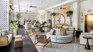 A spacious lobby with a round coffee table, seating areas, and a large wall clock. - Sofitel Legend Casco Viejo, Panama City  (Panama City)