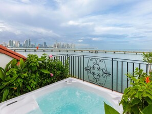 A rooftop pool with a city skyline view, a bridge in the distance, and lush greenery around the pool. - Sofitel Legend Casco Viejo, Panama City  (Panama City)