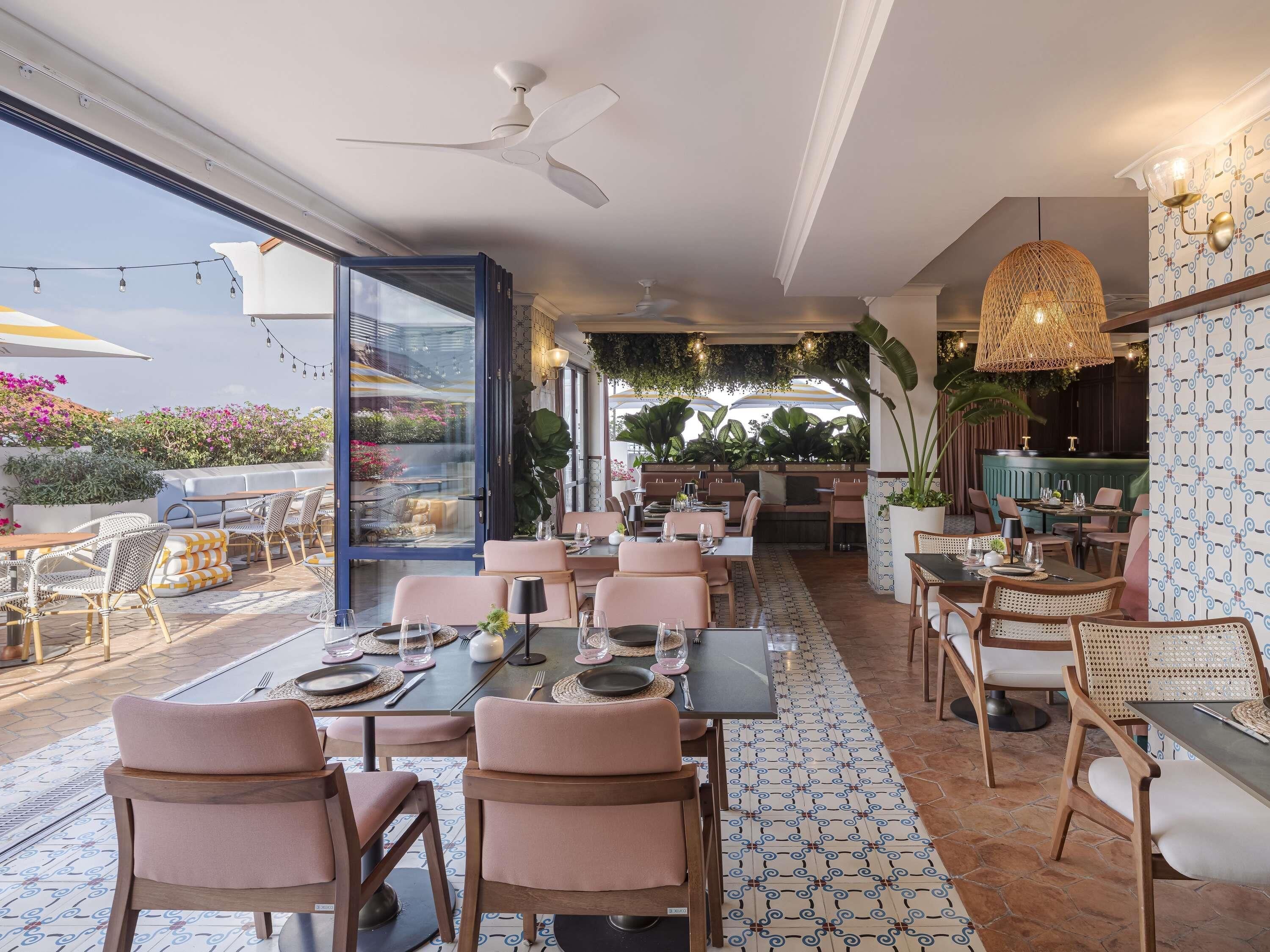 A restaurant with outdoor seating, a ceiling fan, and a patterned floor.