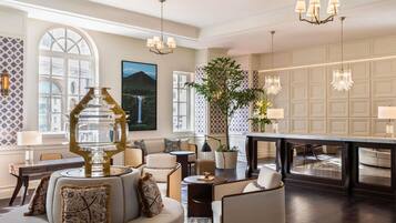 A spacious living area with a large sofa, a dining table, and a chandelier.