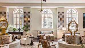 A spacious living room with a high ceiling, large windows, and a decorative ceiling fan. - Sofitel Legend Casco Viejo, Panama City  (Panama City)