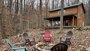 Eine Hütte mit Veranda, umgeben von Bäumen und bedeckt mit Laub.