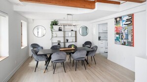 A modern dining area with a wooden ceiling, round mirrors, and a central table with chairs. - Sublime 3BR 2BA Apt | Old Mtl | St Paul ST | (Montréal)