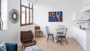 Un appartement moderne comprenant un coin repas, une cuisine et un salon.