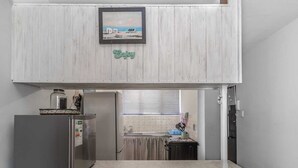 A compact kitchen with a refrigerator, a microwave, and a sink. - Sunny Tides Holiday Inn (Kingsburgh)