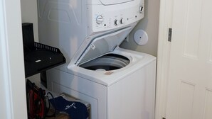 Lavadora y secadora compacta de color blanco con detergente Tide encima.