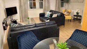 Una sala moderna con un juego de sofá, una mesa de centro y un televisor.
