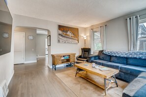Relax in this stylish living room with a blue sofa, leather armchair, and wooden coffee table.