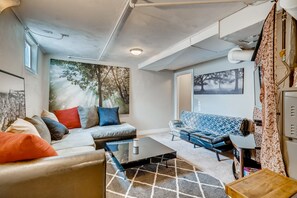 Relax in a cozy seating area with a sofa and couch, surrounded by artwork and a patterned rug.
