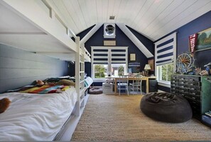Cozy nautical-themed room with a bunk bed, desk area, and bean bag chair.