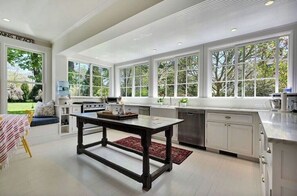 Enjoy cooking in this well-equipped kitchen with a central island, large windows, and a view of the outdoors.