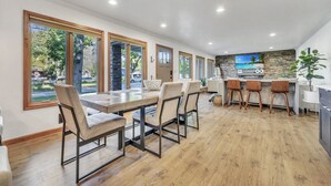 Een moderne keuken met een betegelde achterwand, houten kasten en een groot eiland met barstoelen.