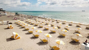 Una playa cerca, arena blanca, sillas reclinables de playa