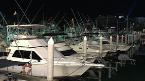 Uma marina com barcos atracados em vagas, um círculo boiando e um pequeno barco com motores de popa.