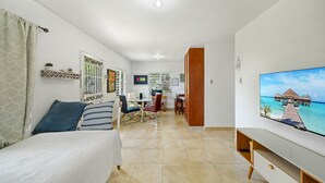 Ett hotellrum med en säng, en TV, ett skrivbord och en matplats.