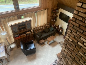 Una sala de estar acogedora con chimenea, un sofá, una mesa de centro y un televisor.