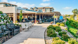 A hotel with outdoor seating, a covered patio, and a landscaped garden.