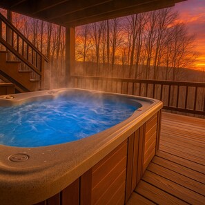 Un bain à remous sur une terrasse en bois, avec vue sur le coucher de soleil.