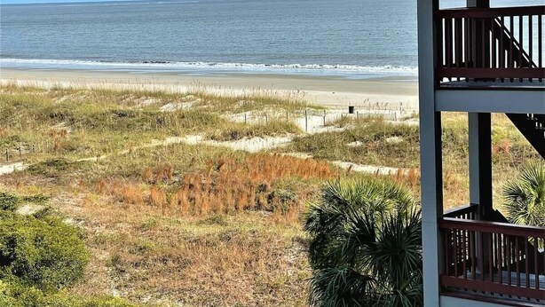 A beach view with a wooden structure in the foreground. - Beachfront Hilton Head Resort 2BR (AR-412): Tennis, Pickleball & Largest Pool (Hilton Head Island)