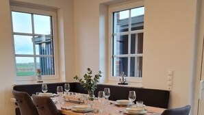 Un'area pranzo con un tavolo in legno, quattro sedie e una finestra vista.