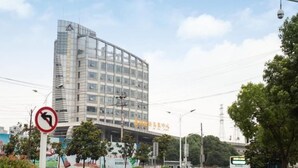 A modern building with a glass facade and signage in a foreign language. - Shell Hefei Chaohu Railway Station Wanda Plaza Hotel (Hefei)