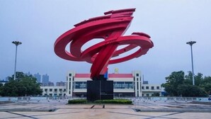 A large red spiral sculpture in an open plaza with a building in the background. - Shell Hefei Chaohu Railway Station Wanda Plaza Hotel (Hefei)