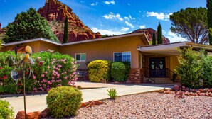 A house with a well-maintained garden, a patio, and a view of a mountain.