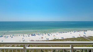 A beach with white sand and clear blue water.